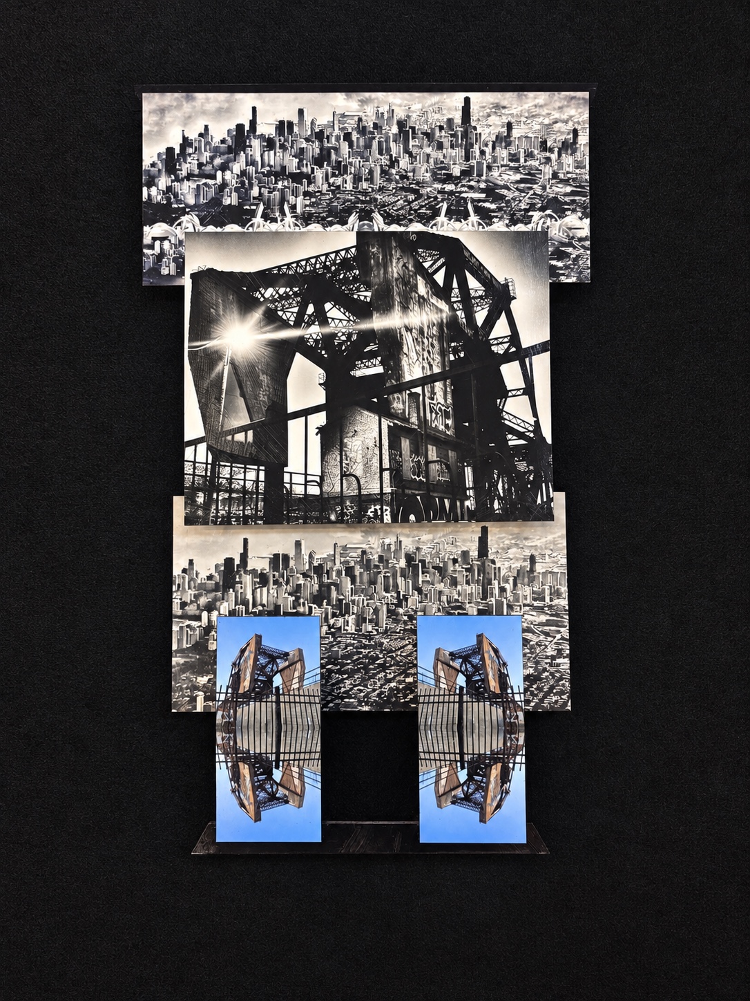 Layered city and bridge construction with a monochrome sunburst and two blue mirrored bridge panels